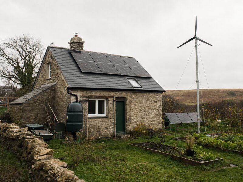 Off-grid cabin with solar panels and battery storage in a wooded setting